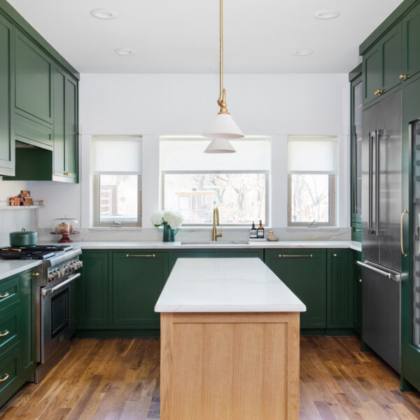 green kitchen cabinets with light wood flooring and island