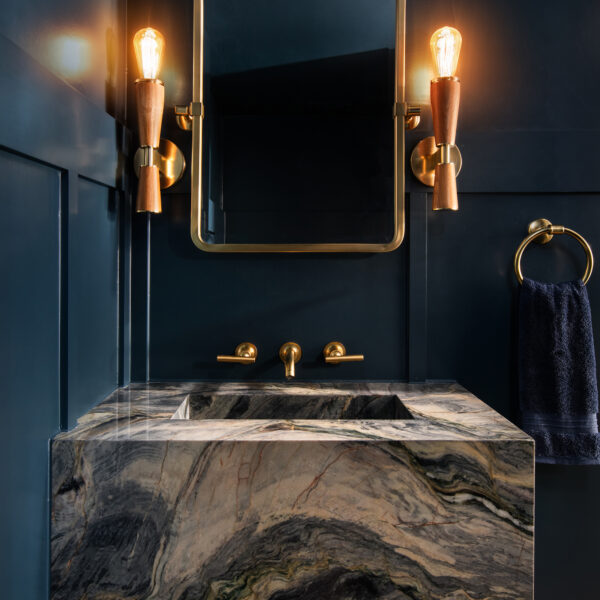 moody navy blue powder room with sconce lighting