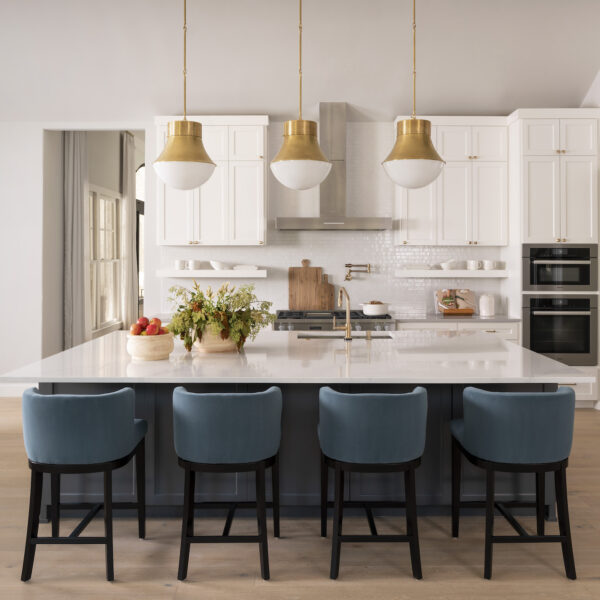 white kitchen with teal bar stools an pendant lights