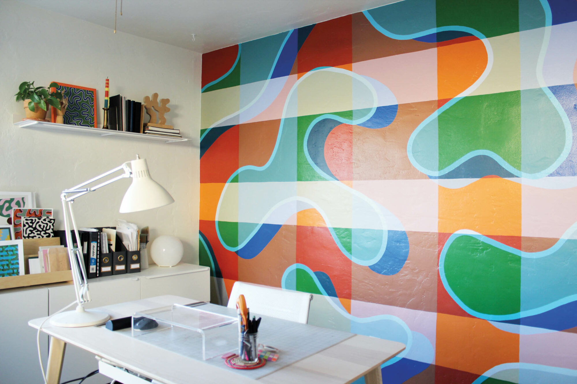 Home office with abstract orange and green mural