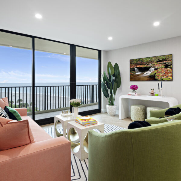Living room overlooking water with colorful seating.