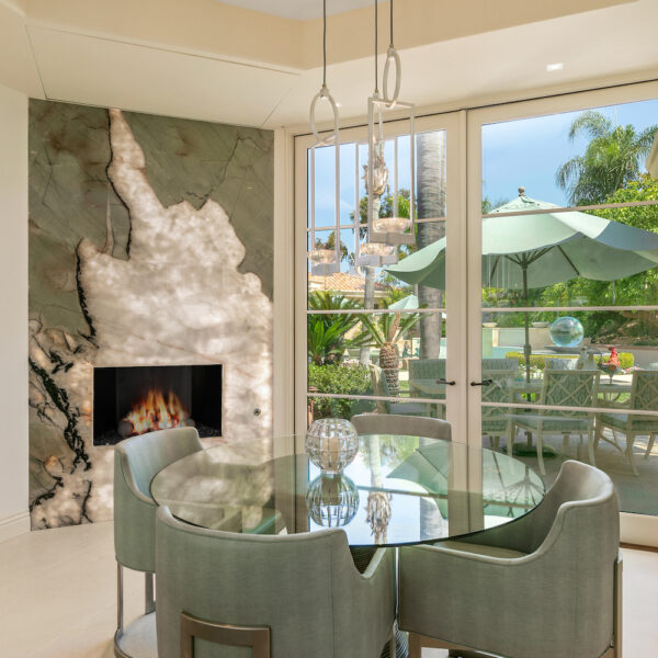 breakfast nook in southern California home with fireplace and green table and chairs.