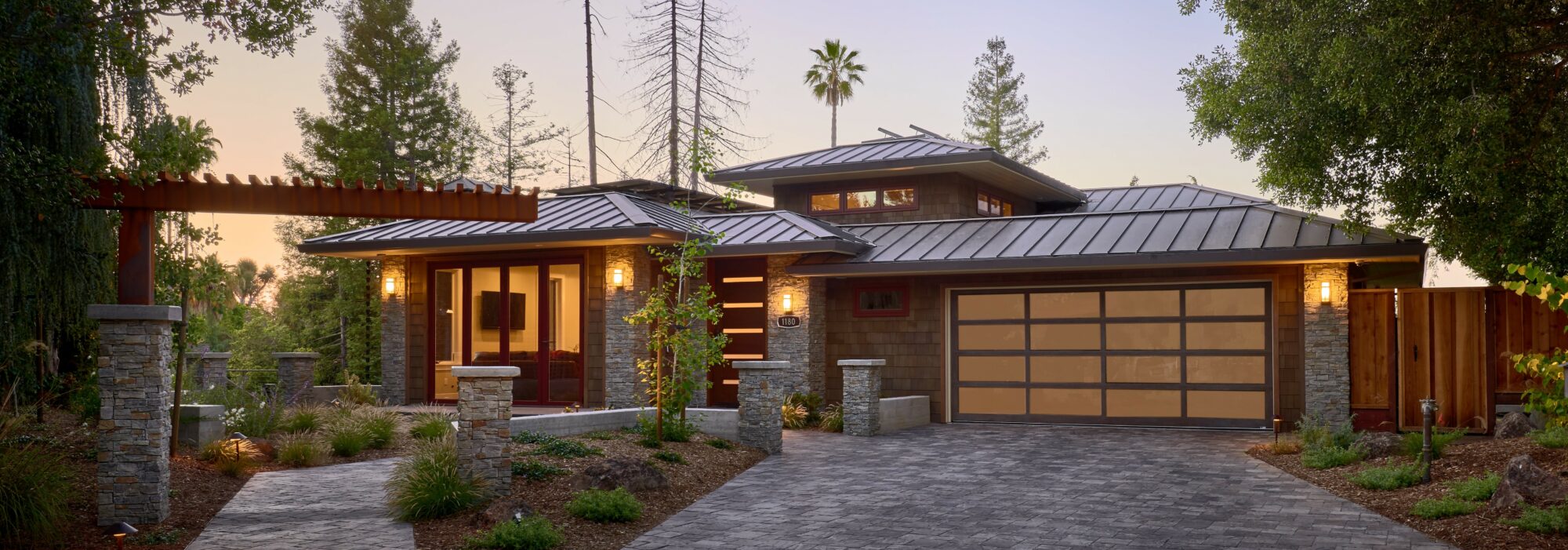 Exterior of Northern California home with tin roof and paved driveway.