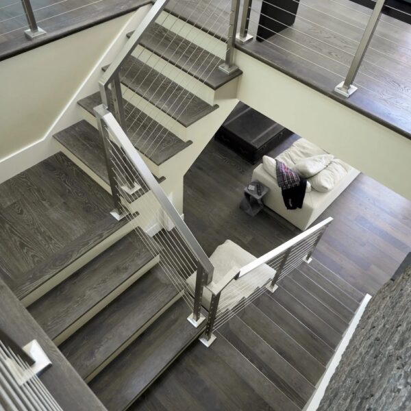 Interior design and architecture in Northern California home with grey wood floor staircase with modern railings.