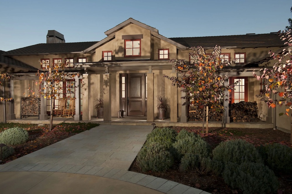 Northern California home with brown facade and red windows frames.