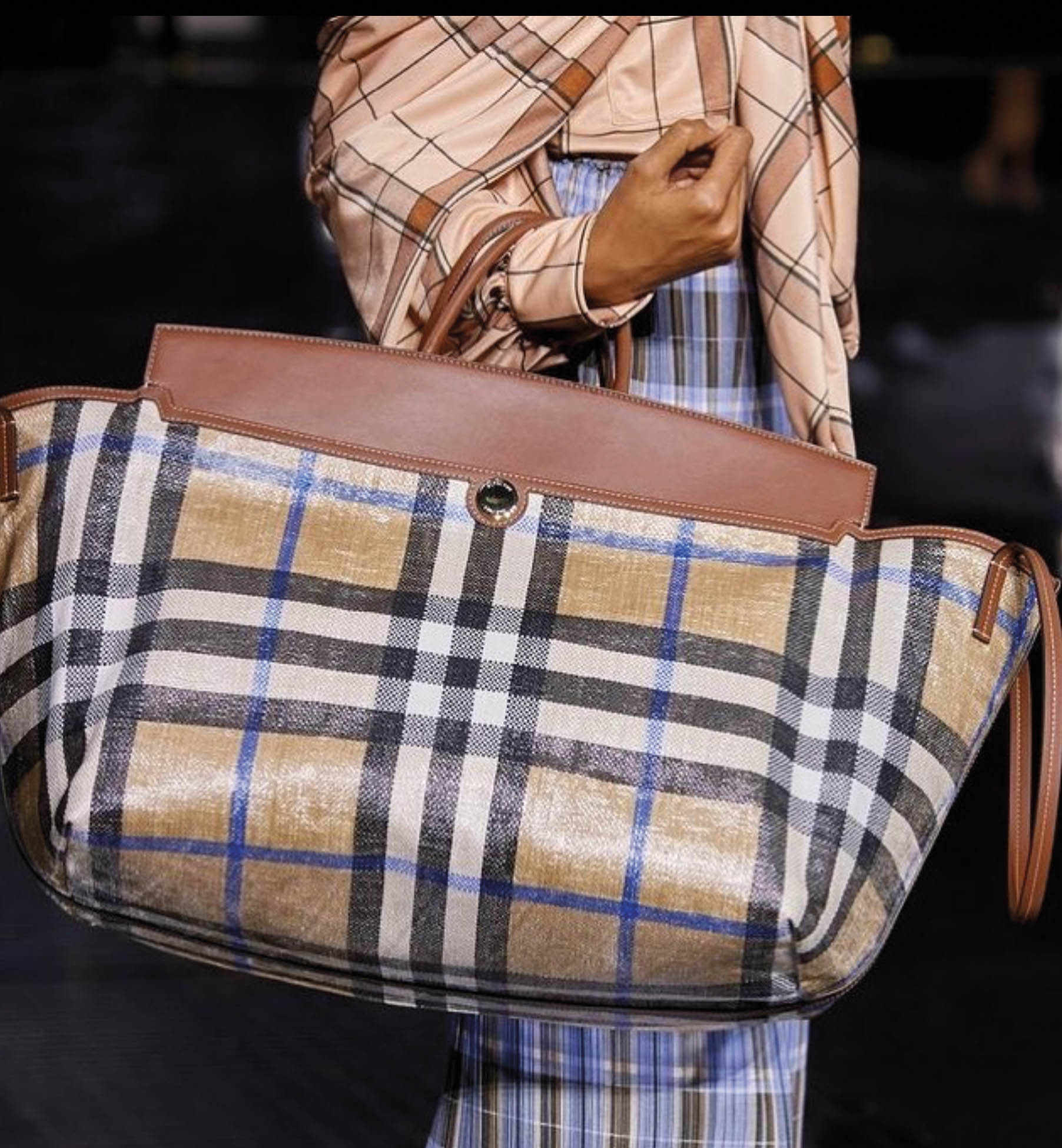 Oversize Burberry plaid purse being held by a model