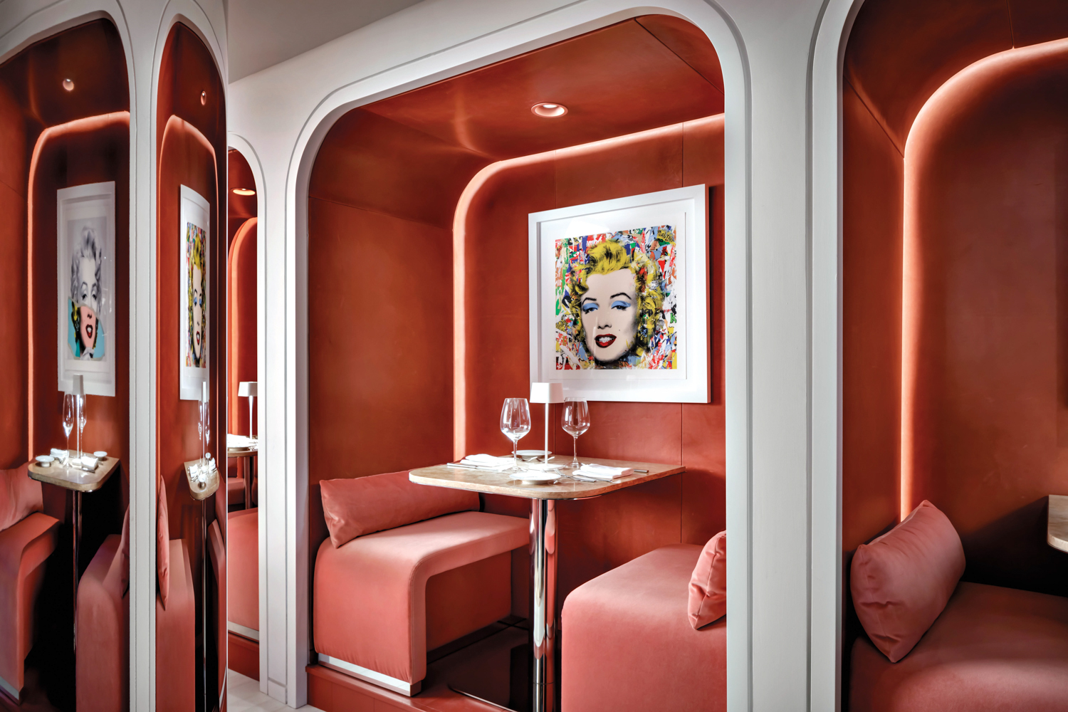 Marylin Monroe pop art piece in a booth with flamingo-pink walls and velvet benches at a Miami restaurant