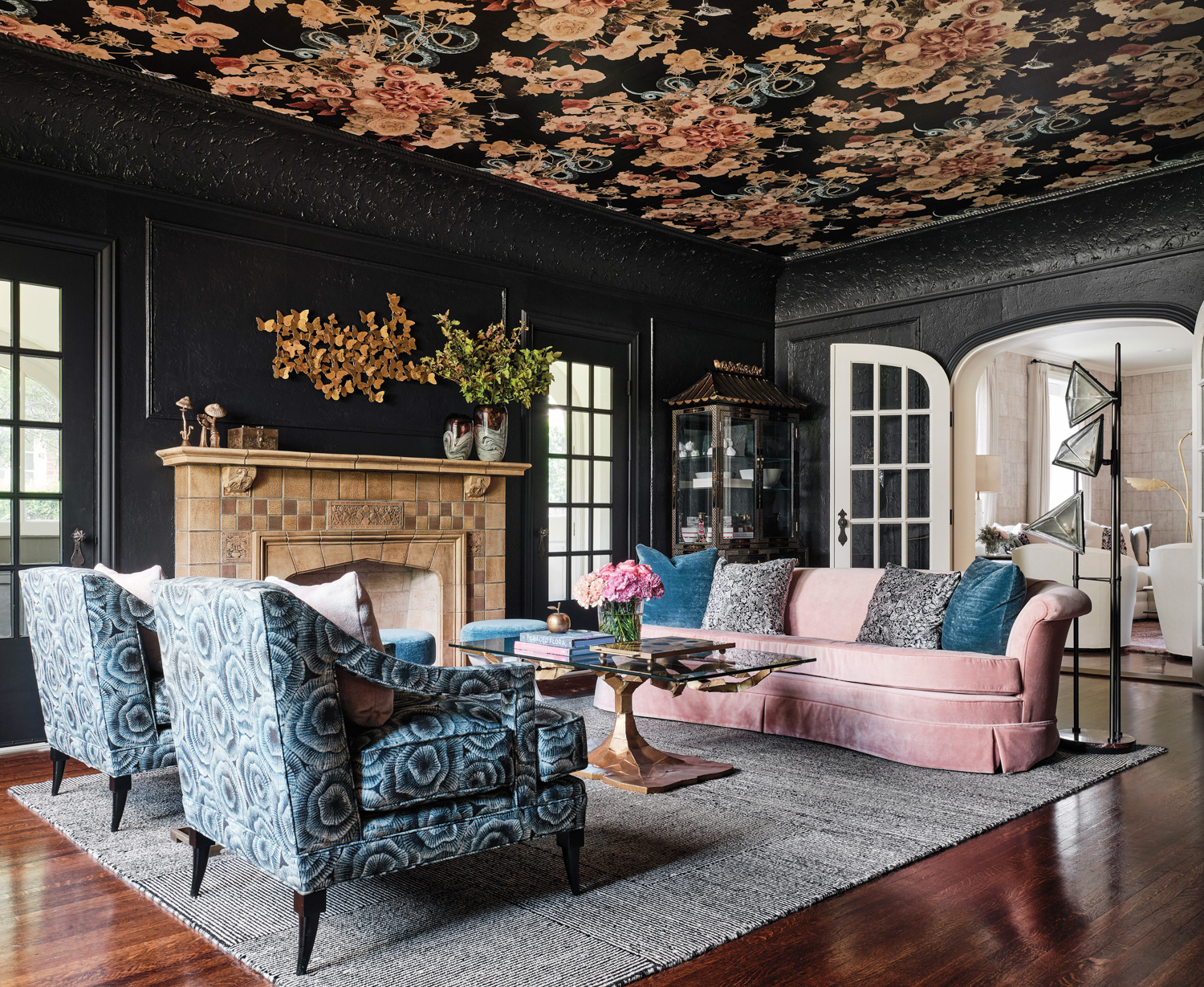 Traci Connell places a blush-velvet settee, blue armchairs, and a wallpapered ceiling in living room