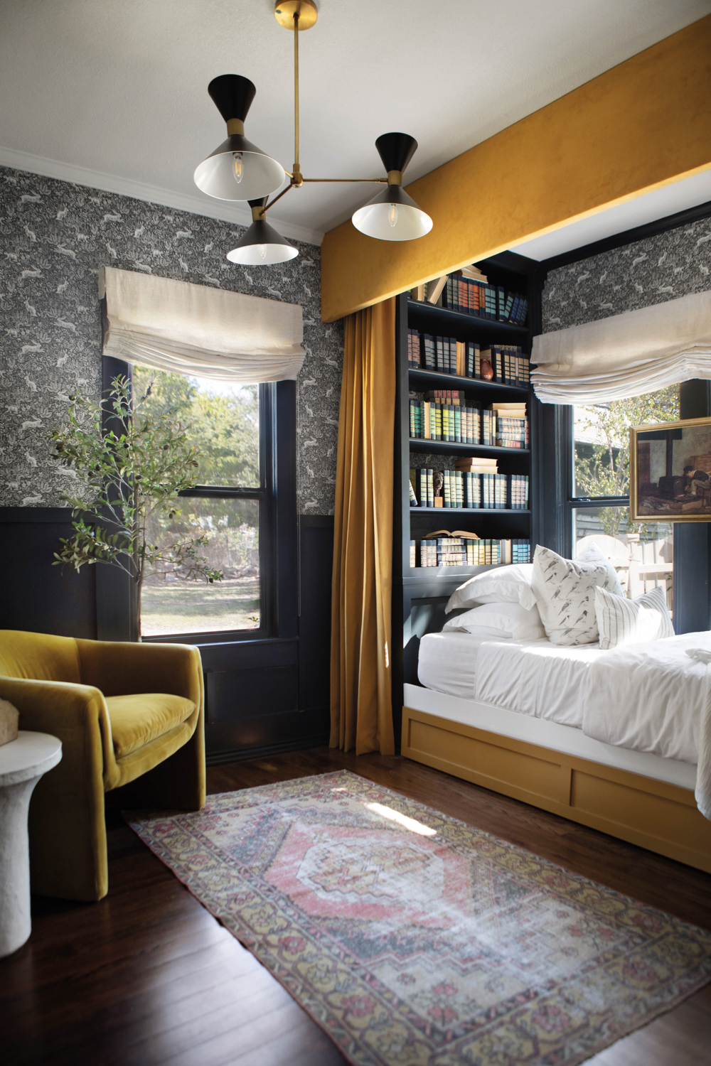 Urbanology Properties room with a vintage rug, a yellow-velvet chair and a bed with gold-yellow curtains