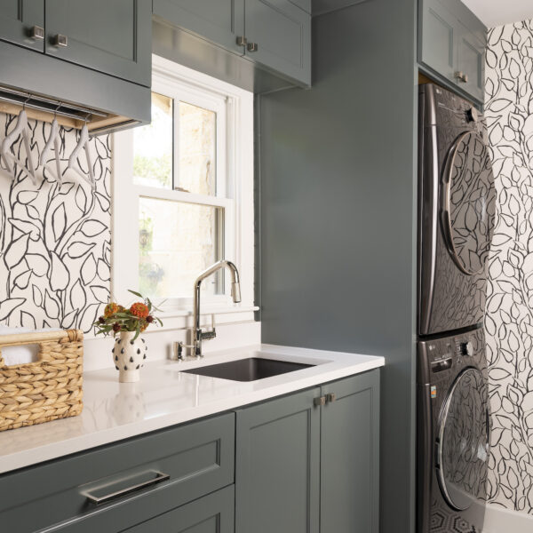 patterned laundry room with built in cabinets and sink