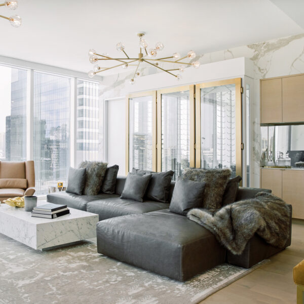 living room with gray sofa and floor to ceiling windows