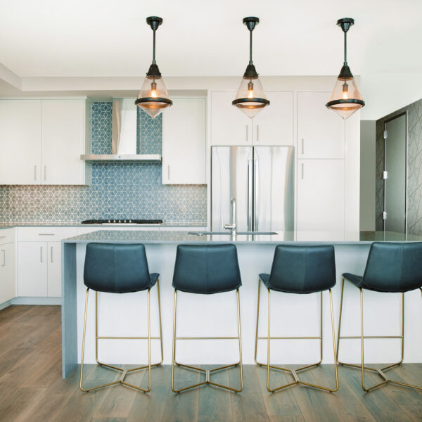 white kitchen with blue tile accents and blue bar stools