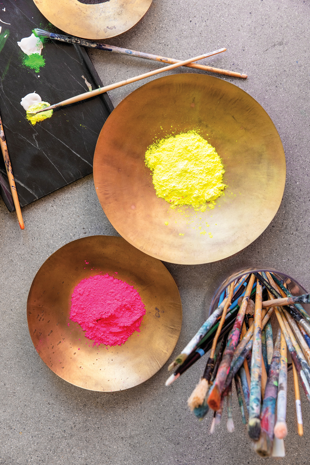 bowls holding bright ground pigments of yellow and hot pink