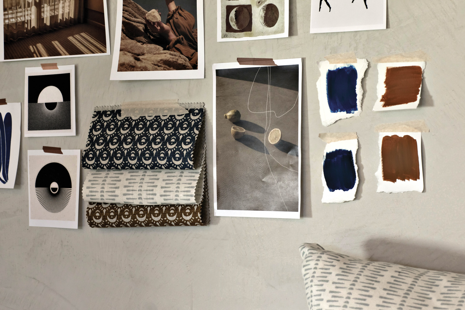 A moldboard including swatches of patterned fabric, photos and paint swatches all pinned on a wall