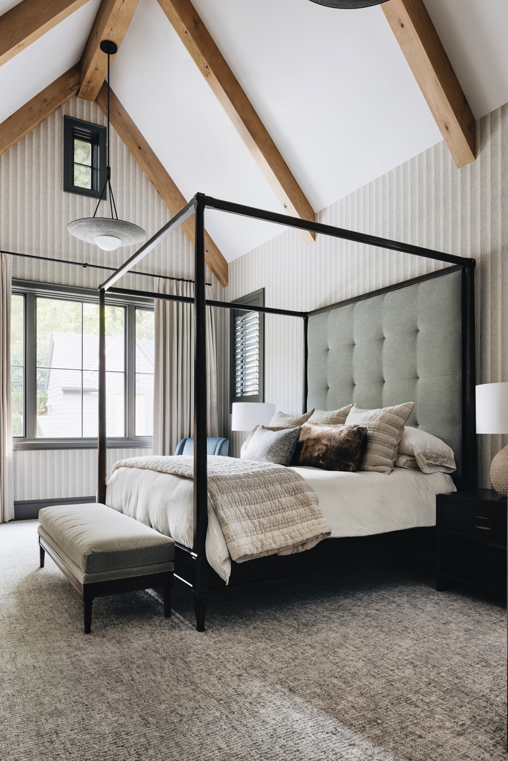 gray bedroom with vaulted wood-beam...