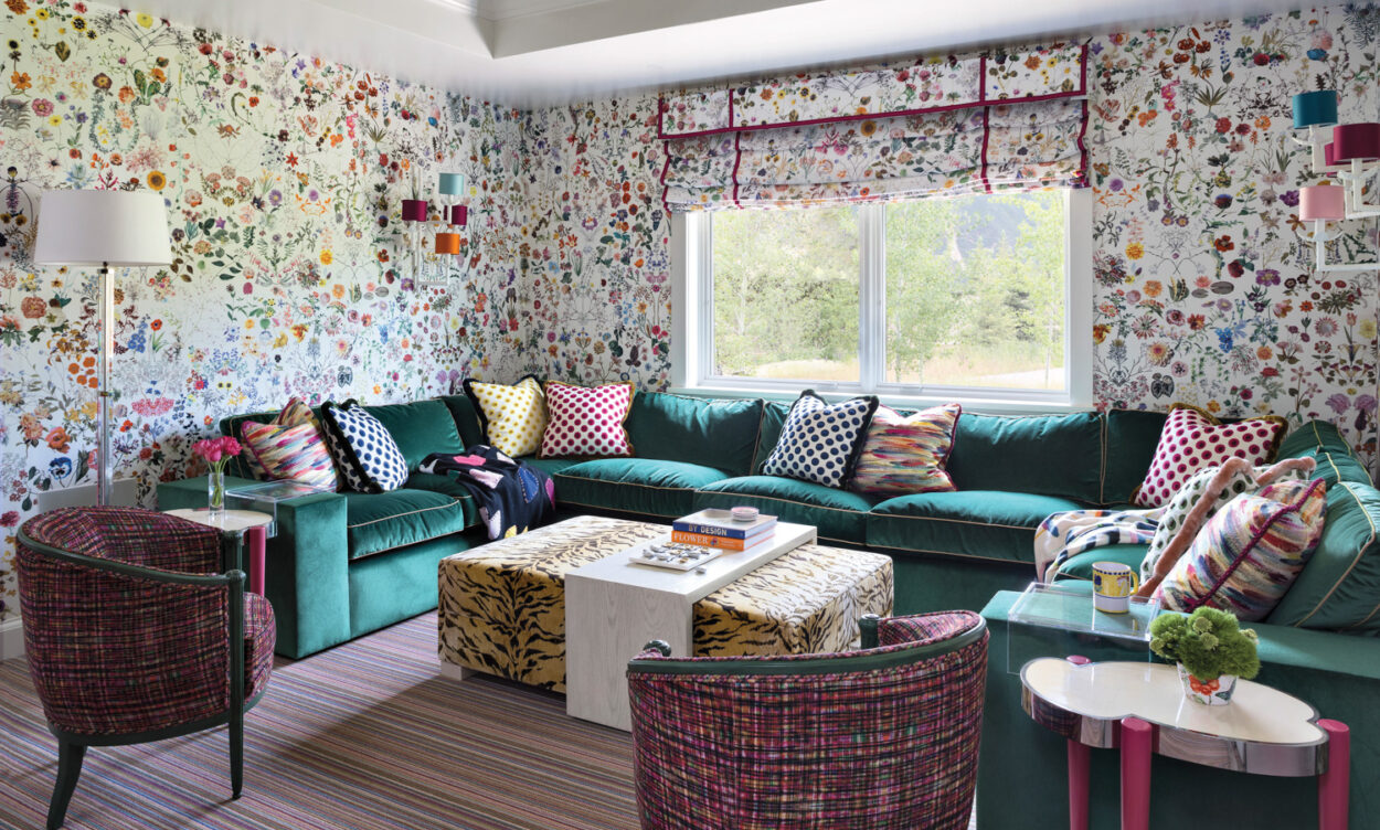 Room with floral wallpaper, teal sectional, green painted ceiling, tiger-print table and striped rug