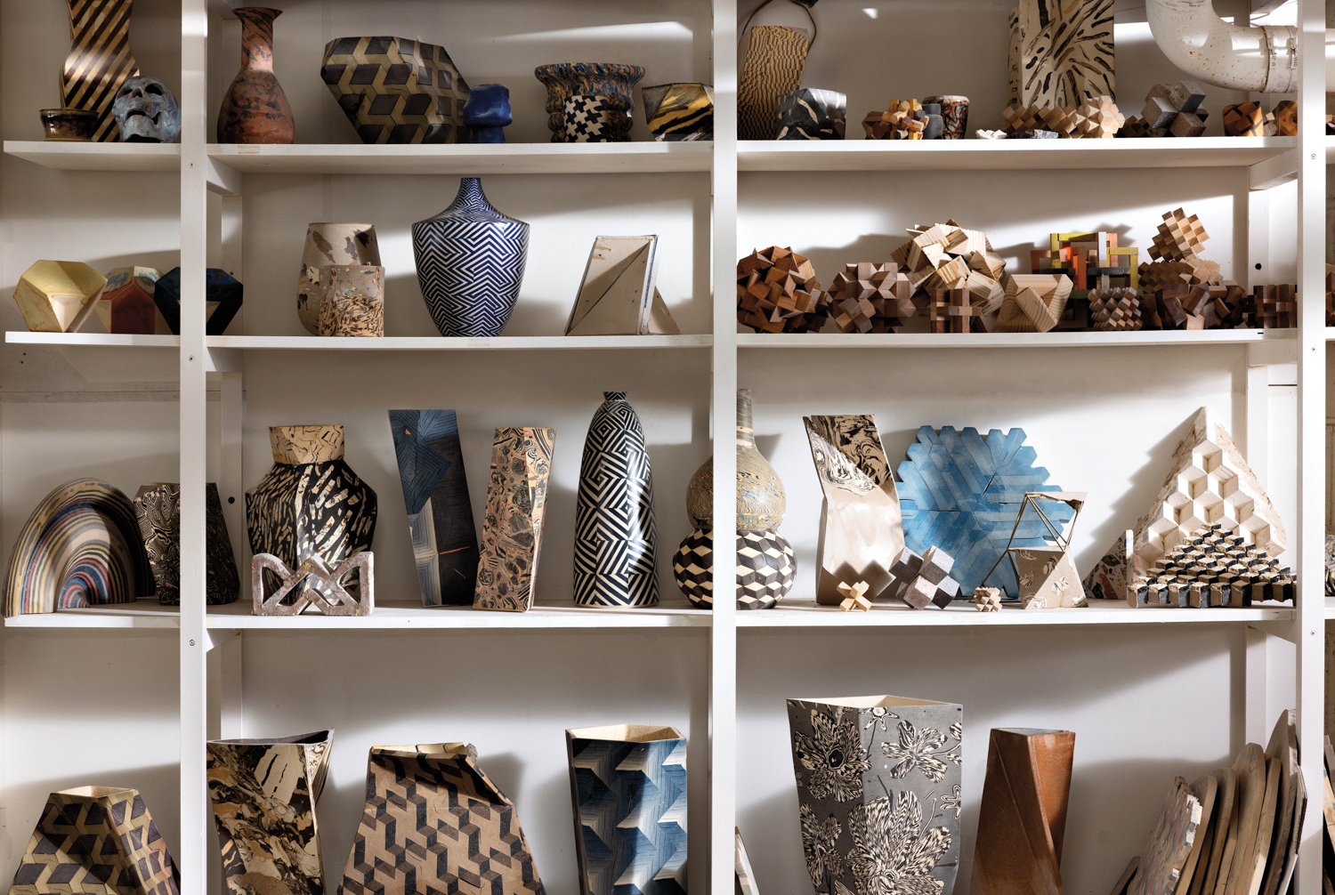 shelf full of different geometric inspired pottery