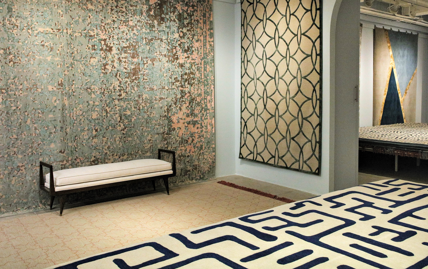 Jennifer Manners showroom with a bench against a wallpapered cover and a geometric fabric on display in the forefront