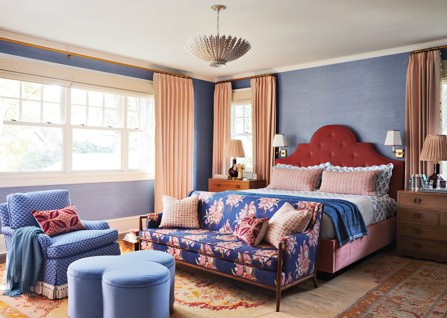 Bedroom with a custom bed, peach drapes, patterned settee, blue furnishings and blue wallcovering