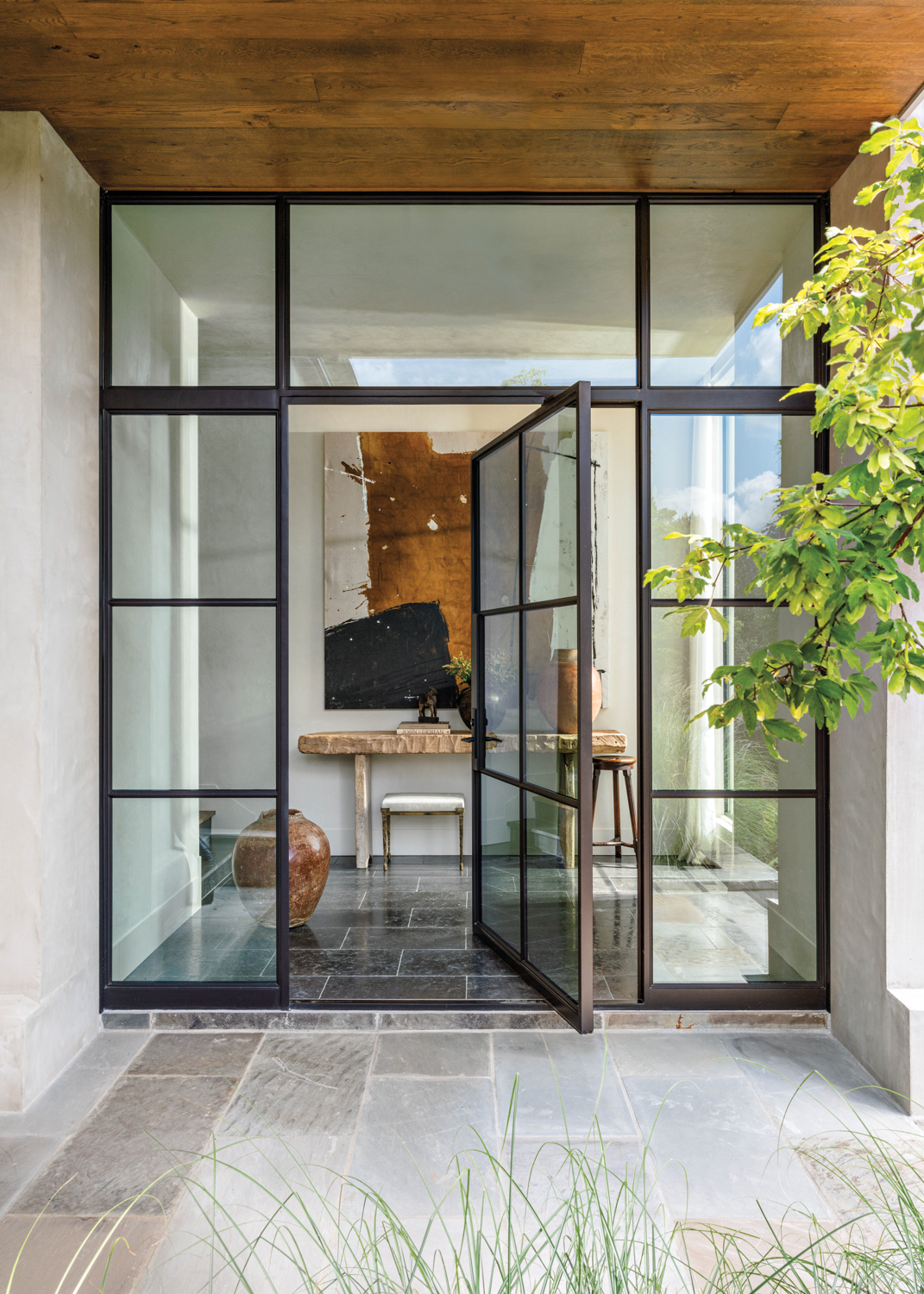 Entryway with pivoting glass-and-steel door,...