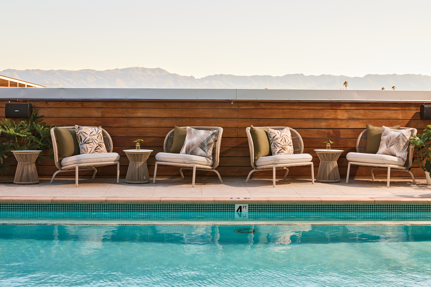 Rooftop pool lounge Eden lined with chairs and side tables overlooking mountain views