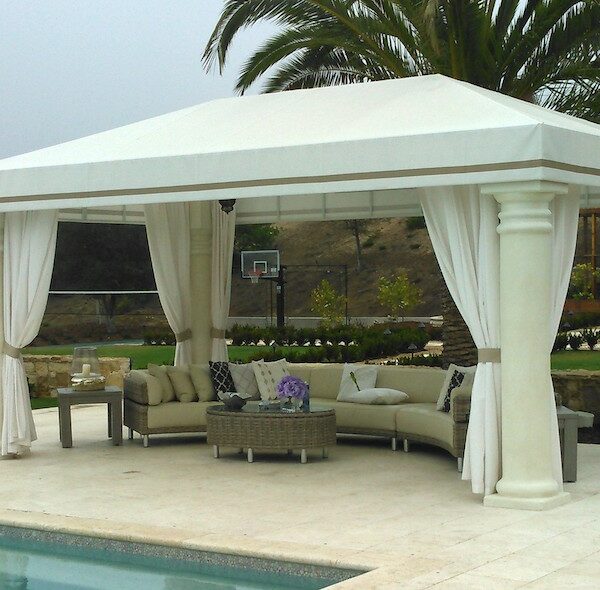 white cabana with drapes and round outdoor sectional