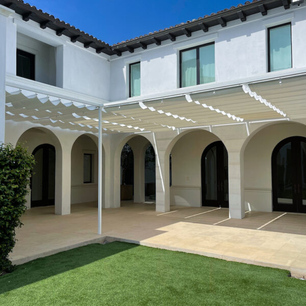 exterior of white home with curved doors and custom wire awnings