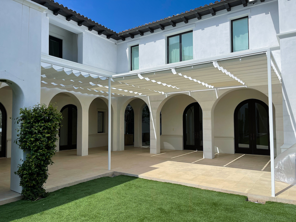 exterior of white home with curved doors and custom wire awnings
