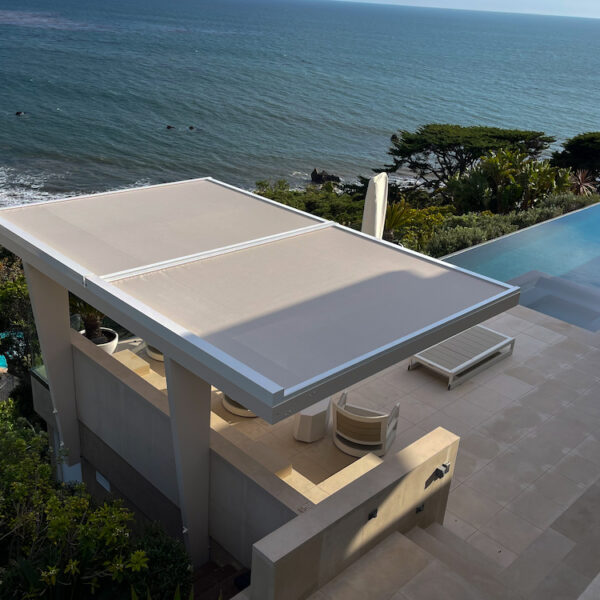 modern home with custom shade coverage and infinity pool overlooking ocean