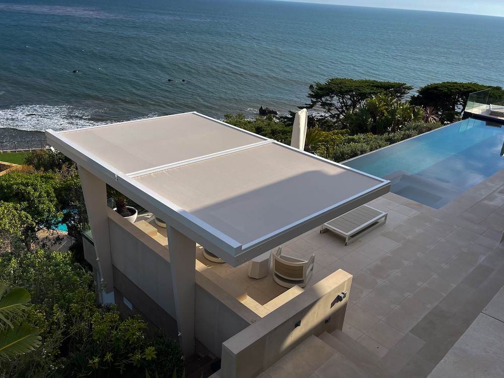 modern home with custom shade coverage and infinity pool overlooking ocean