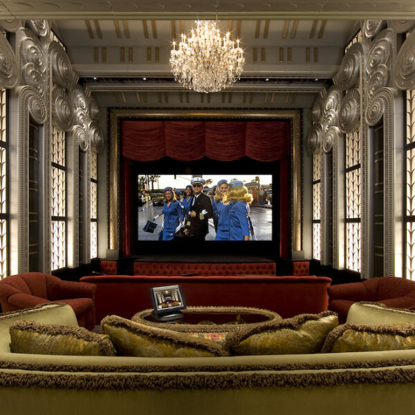 opulent home theater with chandelier and red and gold couches