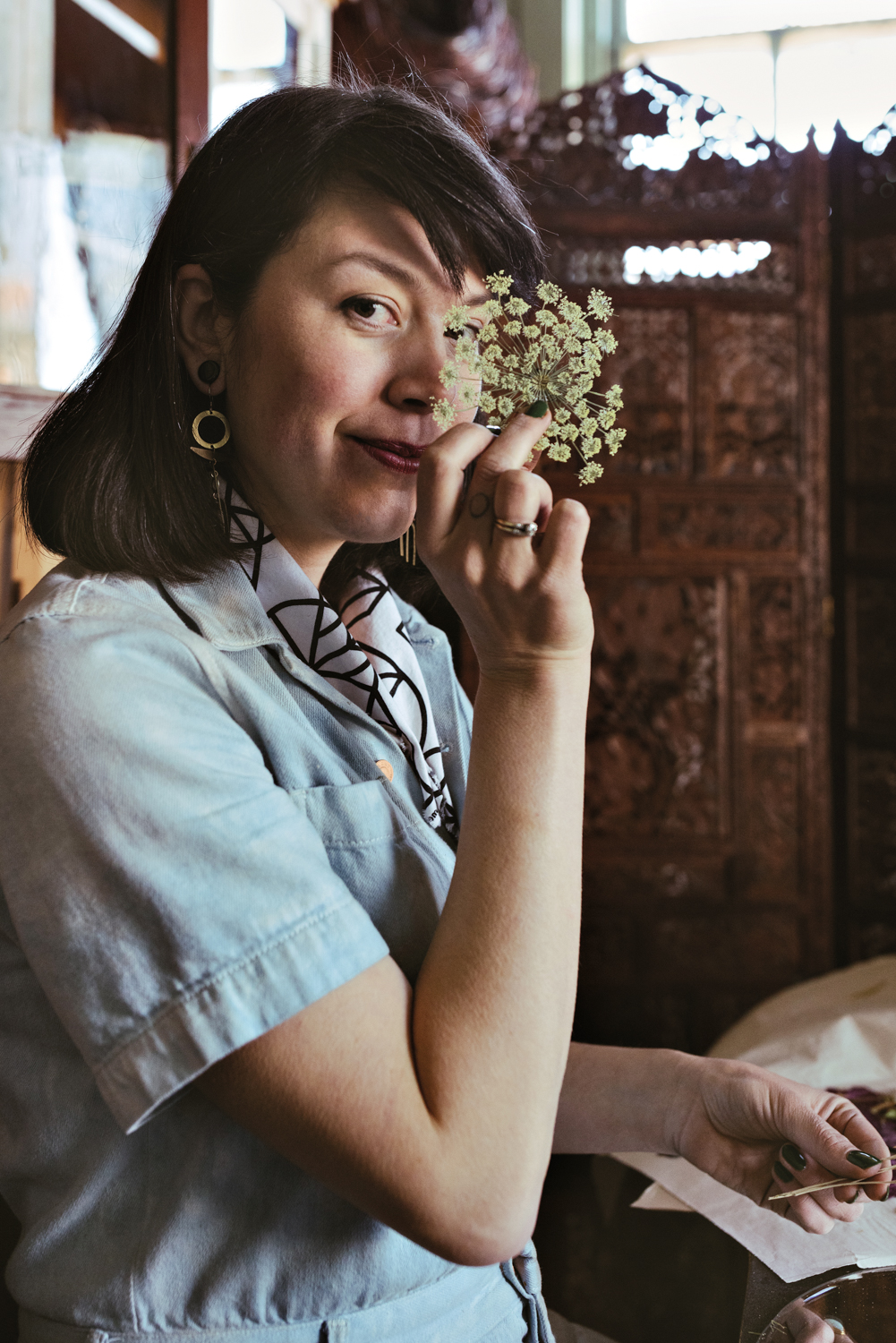 portrait of artist Eileen Roscina holding pressed Queen Anne’s lace near her face