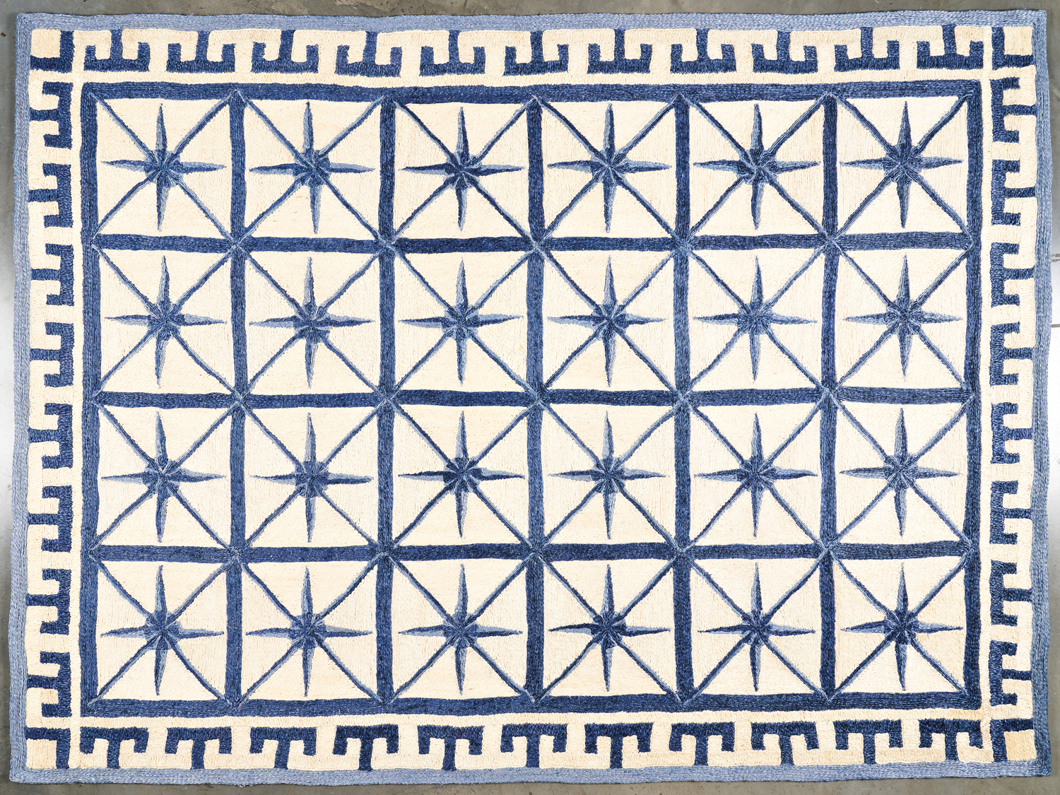 blue and white rectangular rug with compass motifs