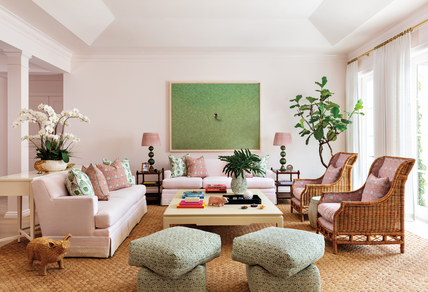 Barbiecore interior design living area with pink sofas and rattan armchairs