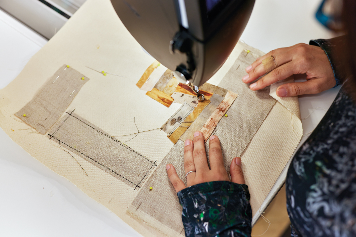 close-up of artist regina jestrow using a sewing machine