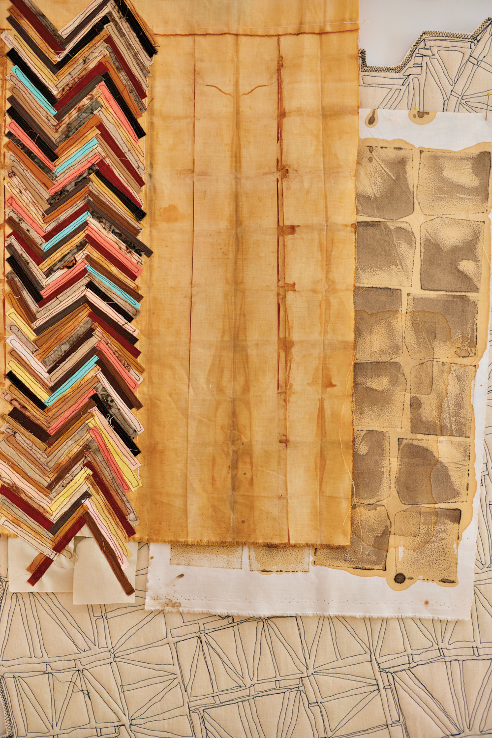 close-up of various textile and an in-progress quilt in regina jestrow's studio