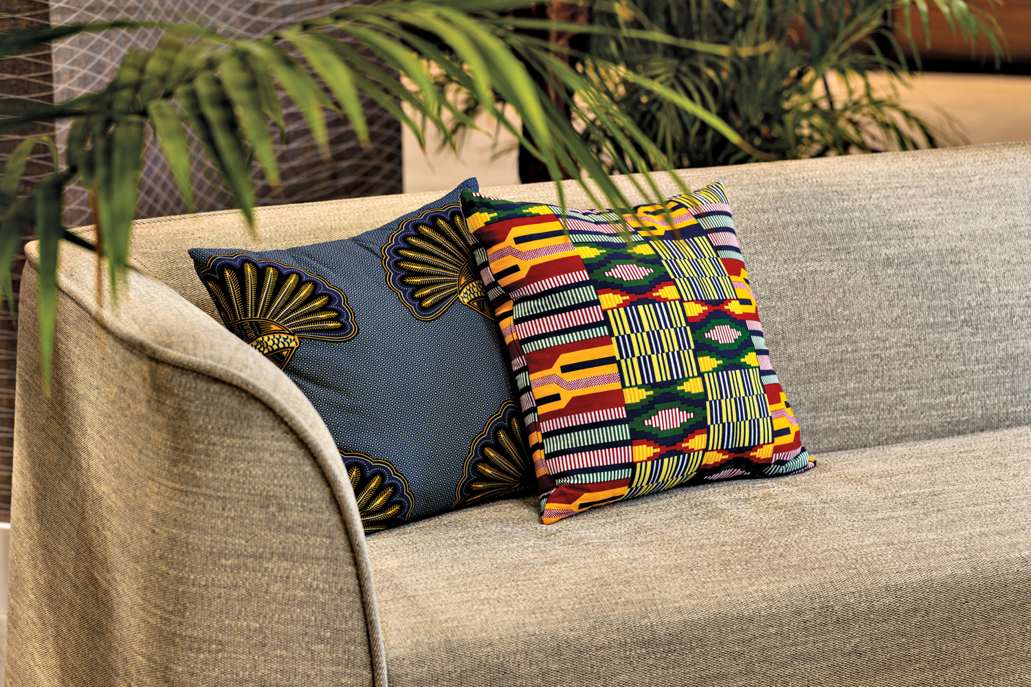 Cream-and-gray sofa holding pillows in colorful textiles.
