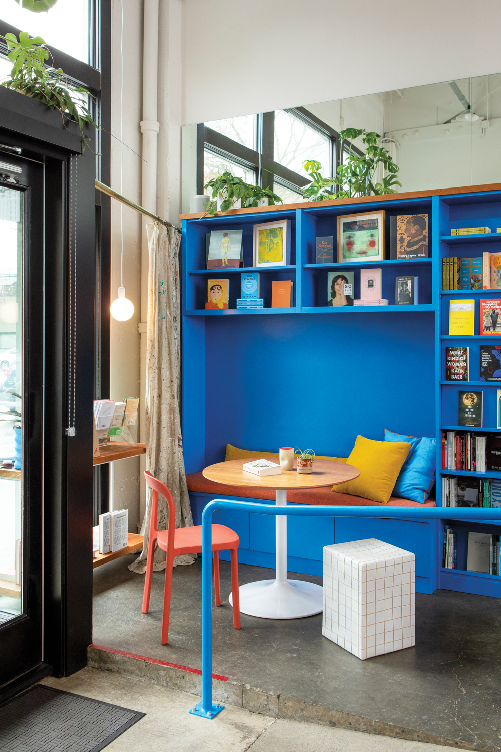 Up Up Books store with bright blue shelves and built-in reading nook