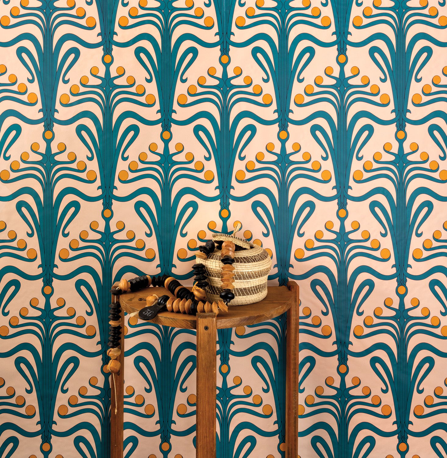Vibrantly patterned teal-and-yellow wallcovering behind wooden side table