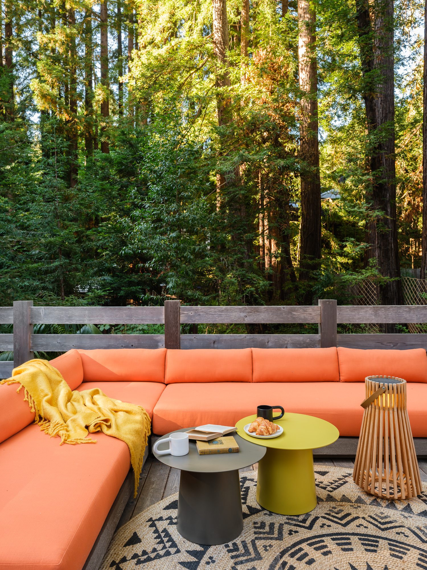 outdoor patio with bright orange sofa and side tables