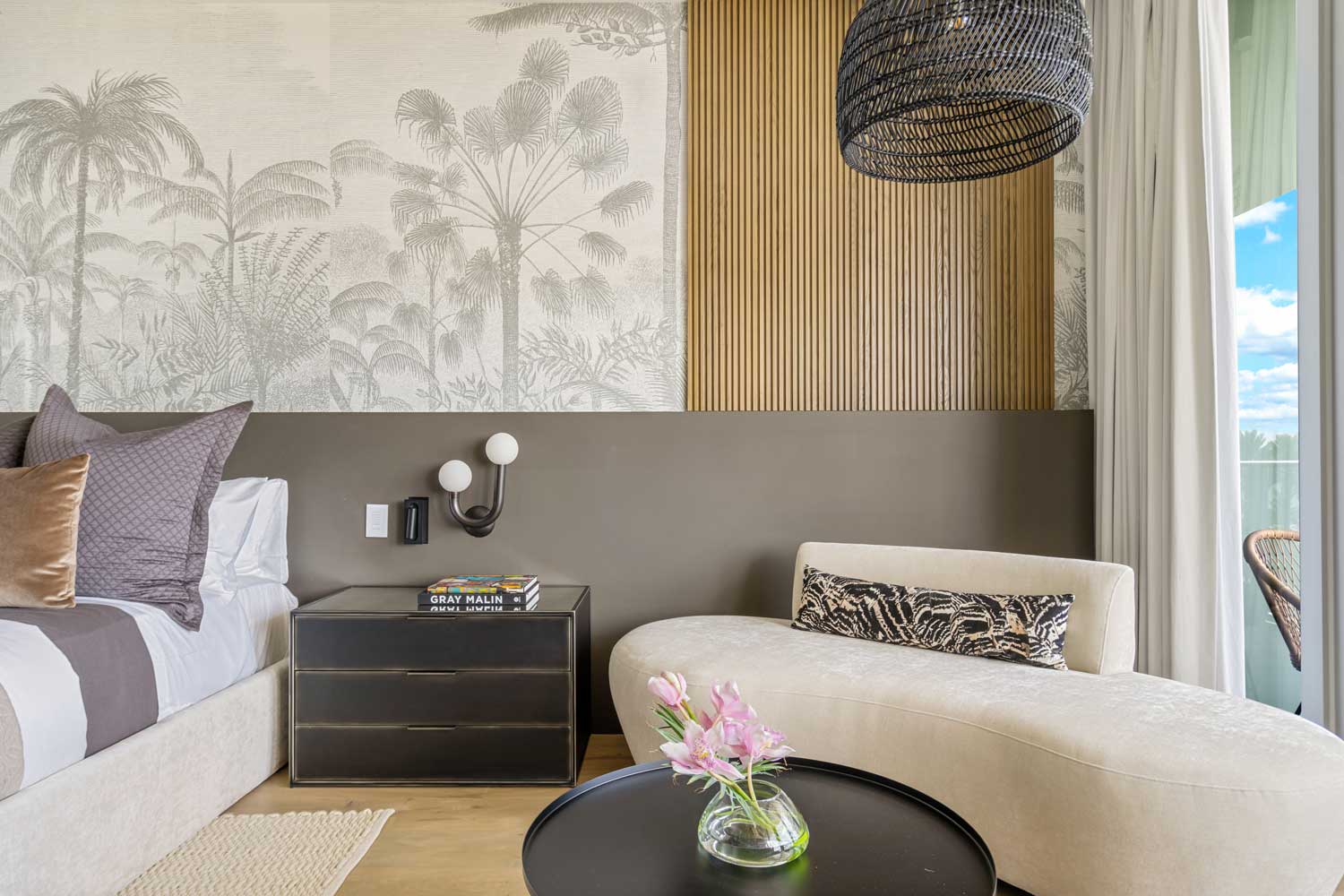 bedroom with textured wallpaper, black light fixture and armchair