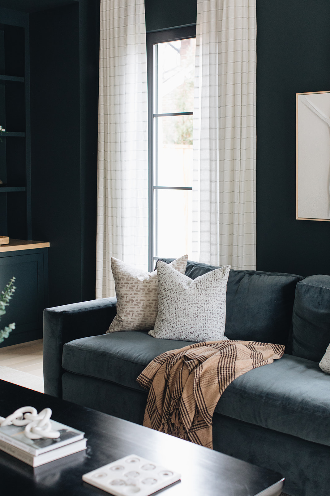 navy blue room with navy blue sofa, printed drapes and pillows