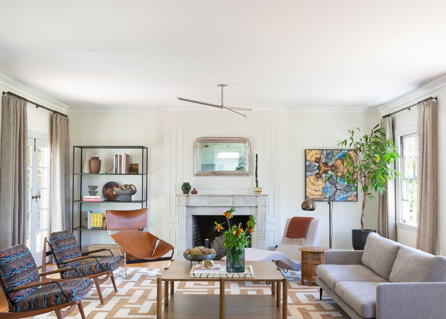 living room with white fireplace and mantel, printed rug and printed chairs