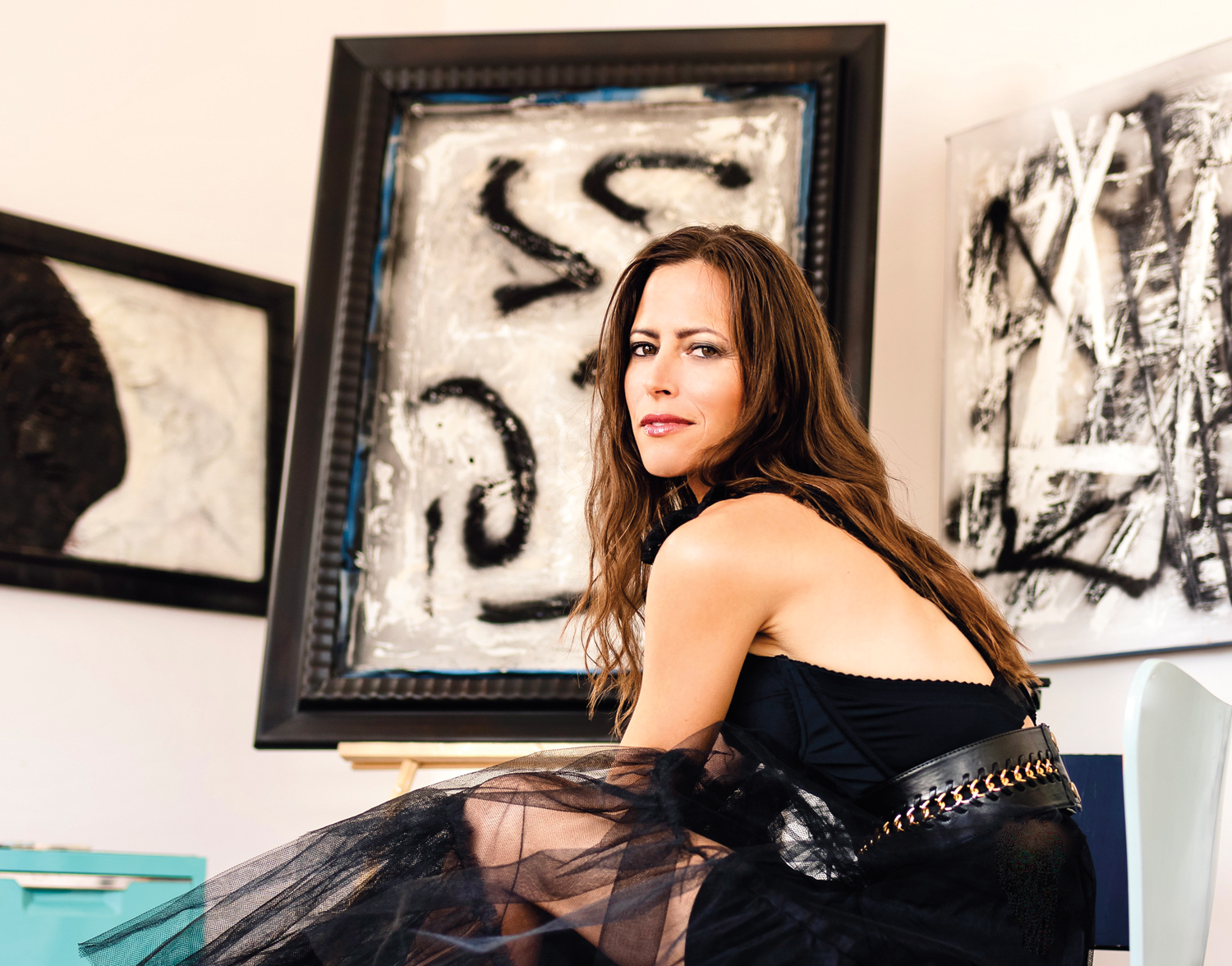 Artist Laura Madden posing with her abstract artwork