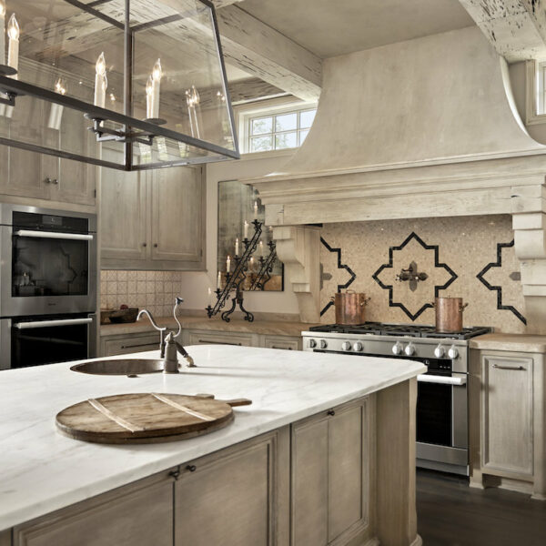 neutral tile backspash in this spacious kitchen with large island and chanedlier