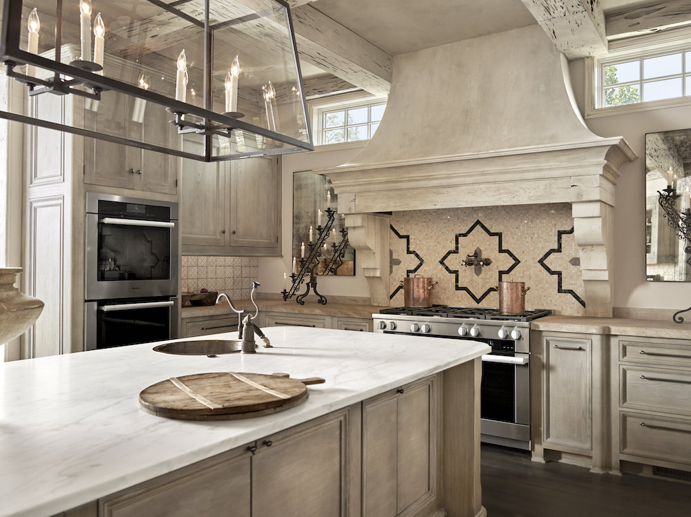 neutral tile backspash in this spacious kitchen with large island and chanedlier