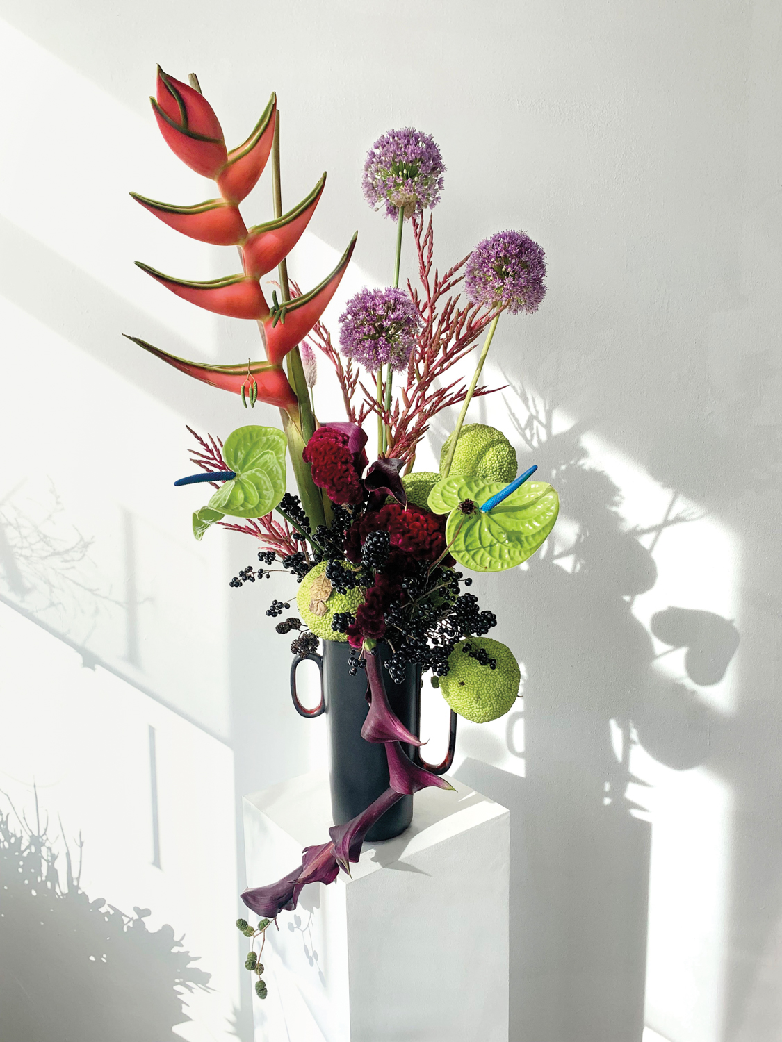 Floral arrangement featuring lime green, bright orange and purple blooms for Exfolia Botanical