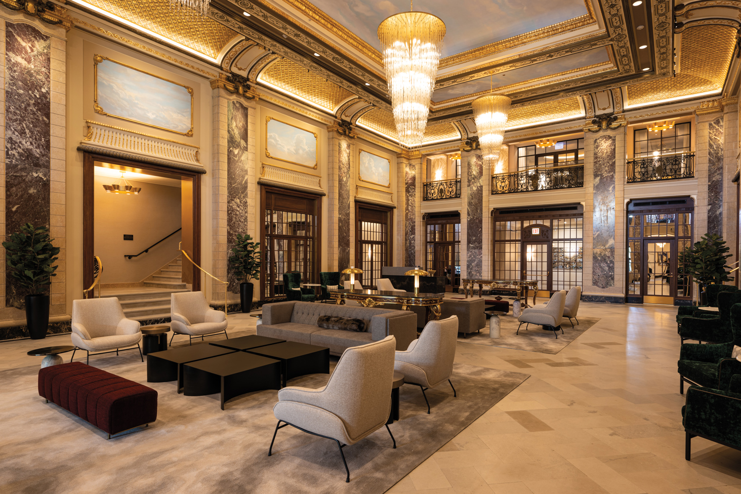 Apartment building lobby with elaborate gold moldings and dramatic chandeliers