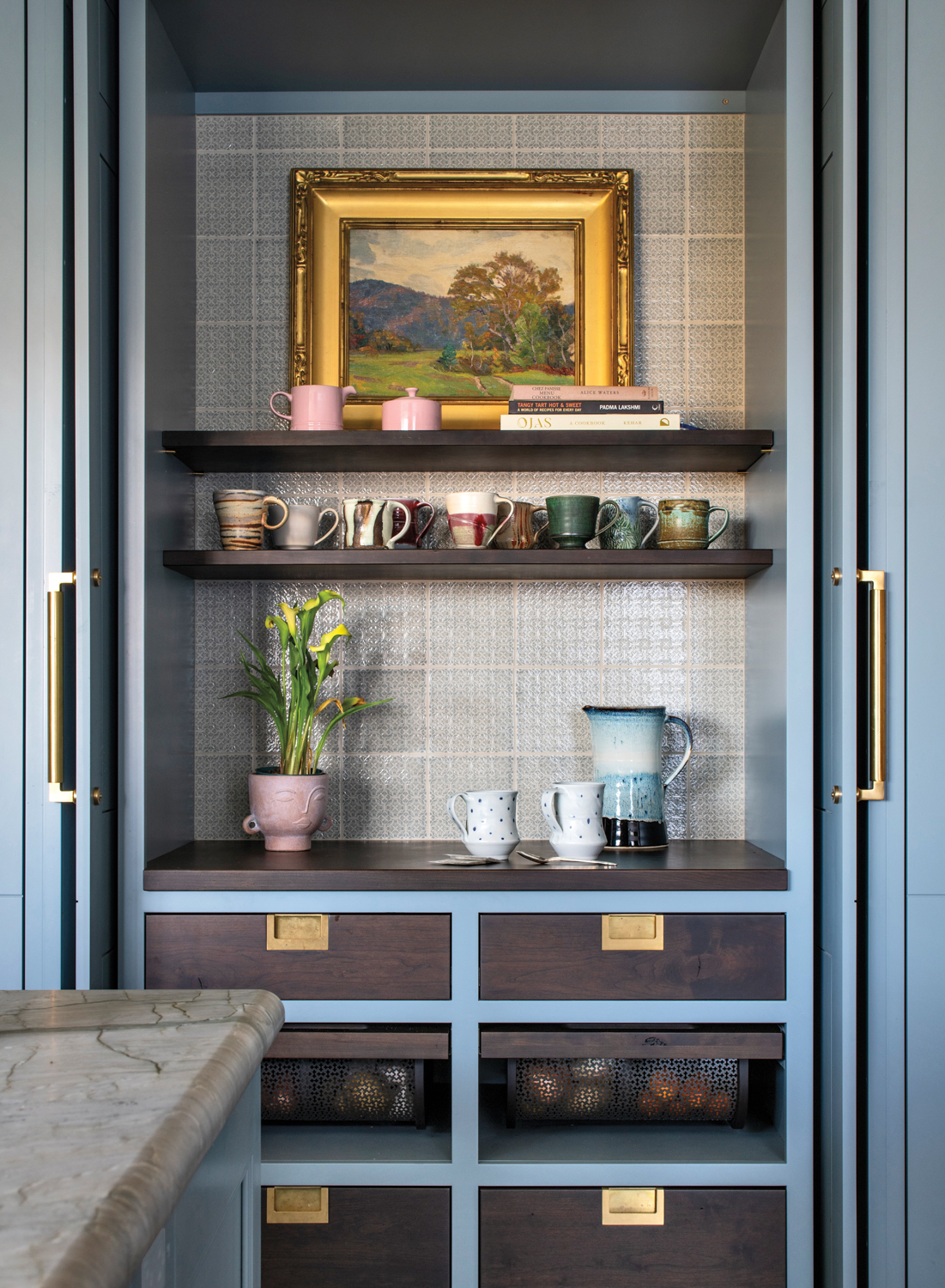 hidden coffee bar behind blue doors with shelving and artwork in kitchen by Sarah Robertson