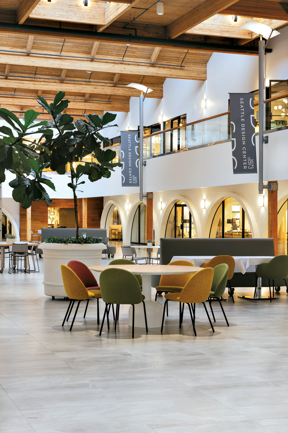 Seattle Design Center area featuring trees in oversize planters and tables surrounded by upholstered chairs